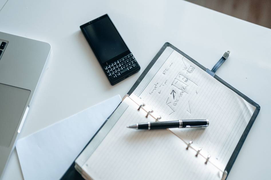 Person meditating beside a tidy desk with planner, laptop, and wellness items